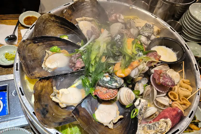 전골 냄비에 가득 담긴 조개와 해산물