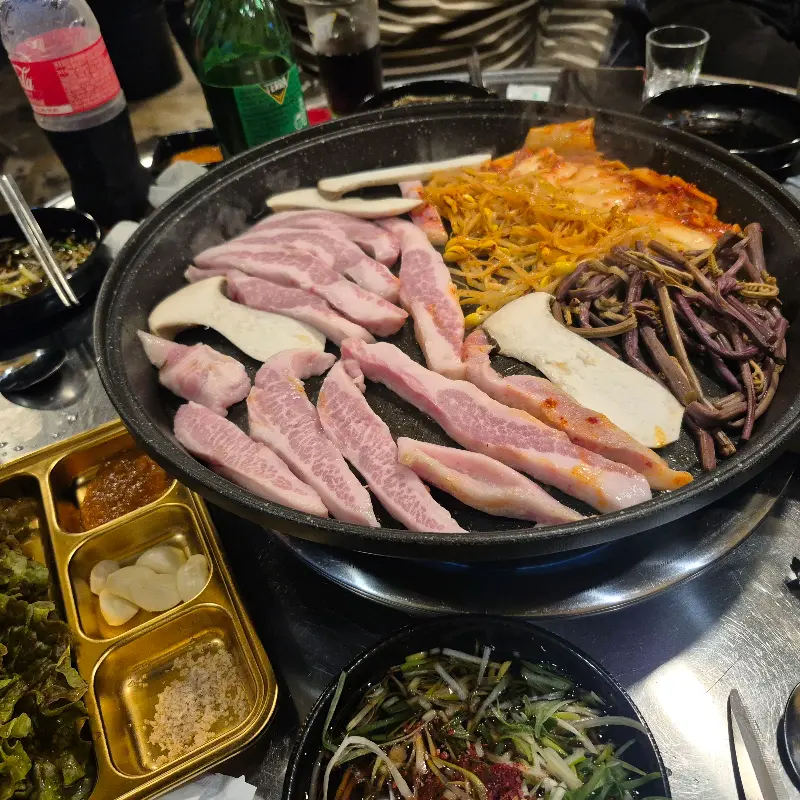 삼겹살, 김치, 콩나물, 고사리, 버섯 등 푸짐한 한 상 차림