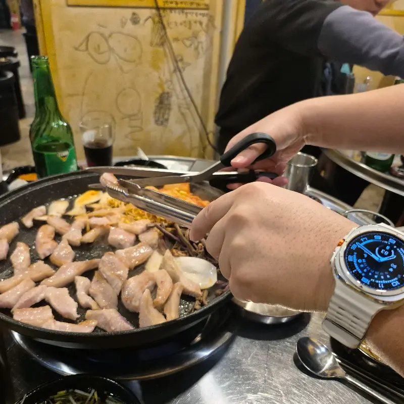 직원이 삼겹살을 먹기 좋게 잘라주는 모습