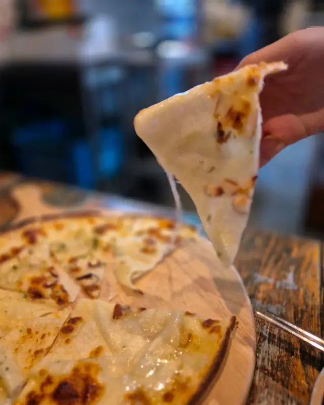 고르곤졸라 피자 조각을 들어올리는 모습