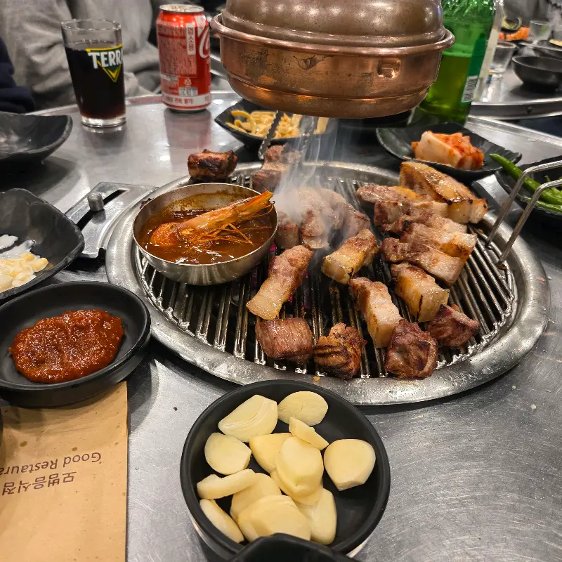 숯불 위에서 익어가는 흑돼지 오겹살과 멜젓