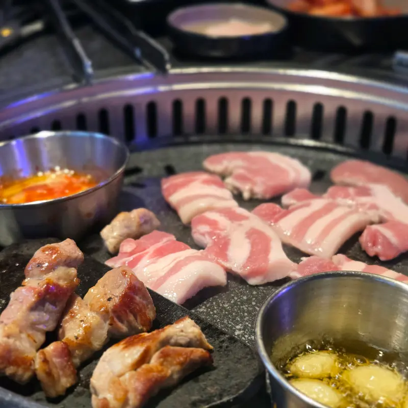 불판 위에서 익어가는 삼겹살과 마늘