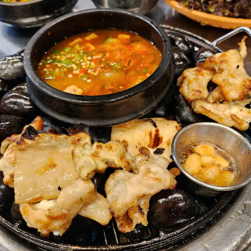 자갈 위에 구워진 닭발과 된장찌개