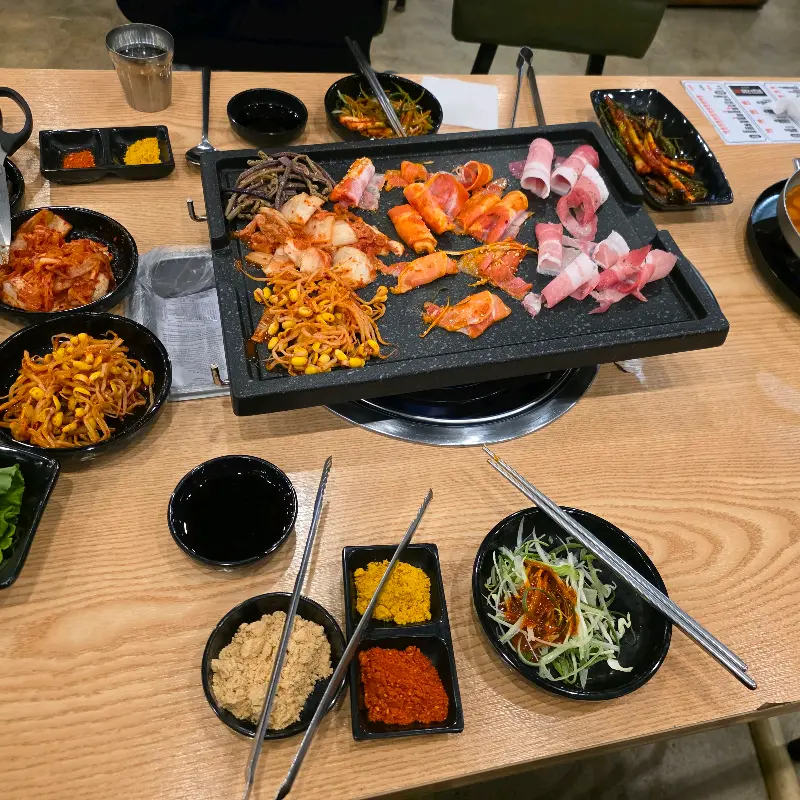 불판 위에 구워진 김치, 콩나물, 고사리