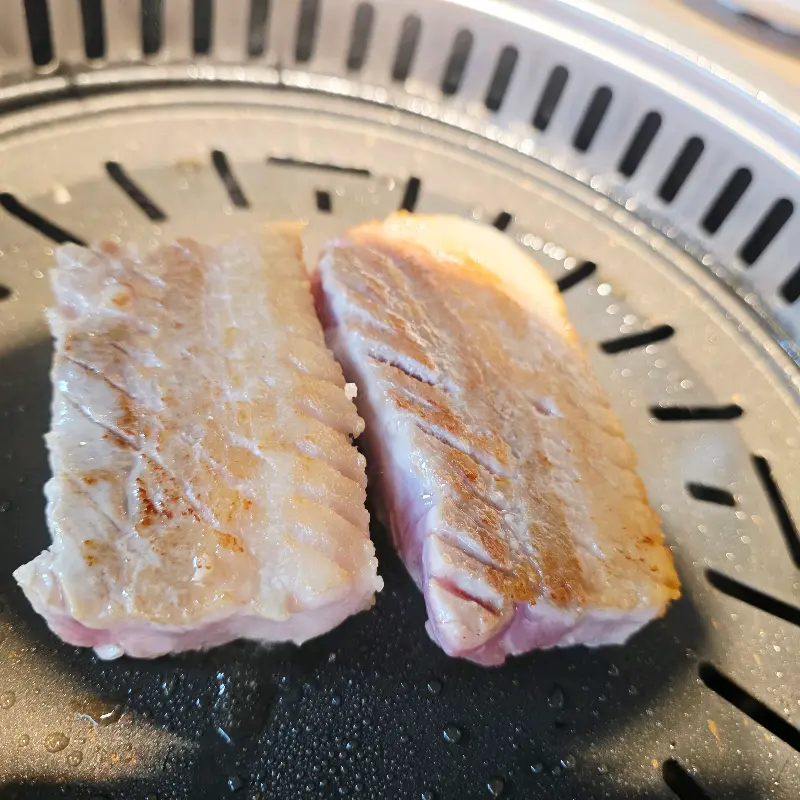 불판 위에서 익어가는 두툼한 삼겹살