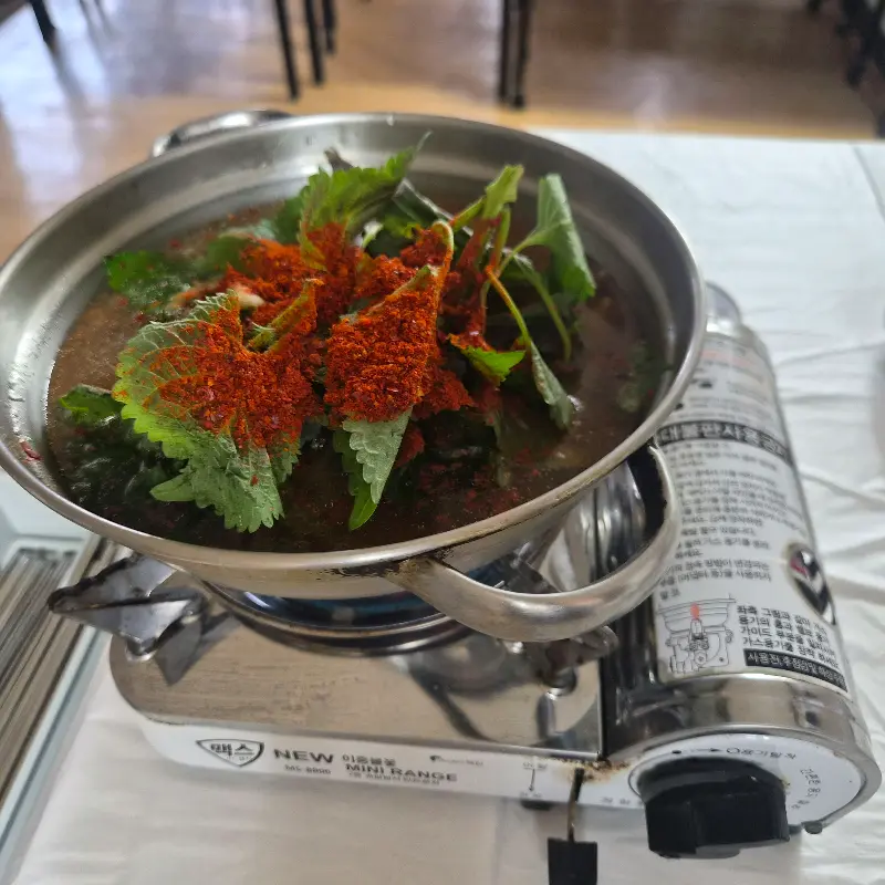 테이블 위에서 보글보글 끓고 있는 매운탕 뚝배기