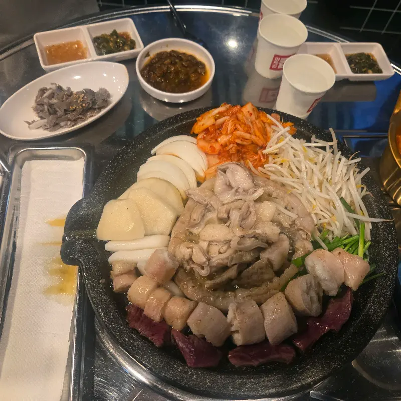 곱창, 대창, 염통과 함께 곁들임 메뉴들이 테이블에 가득 차려진 모습