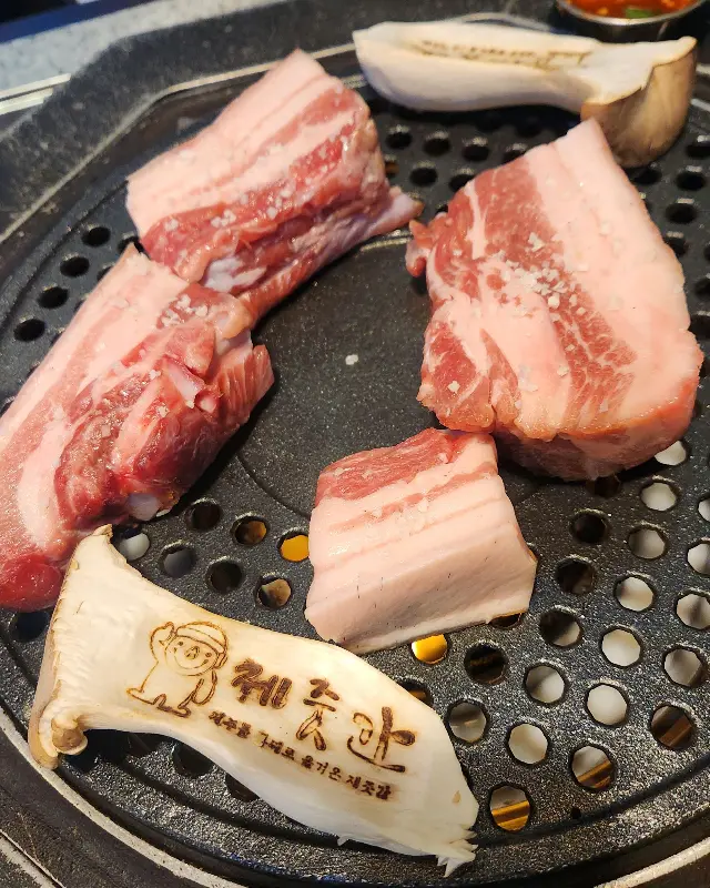 불판 위에서 노릇하게 익어가는 돼지고기