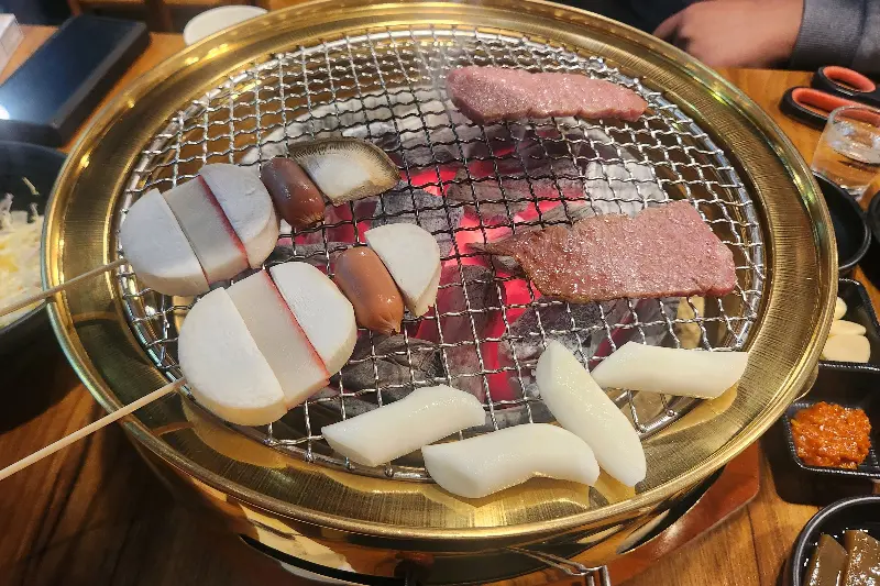 숯불 위에서 구워지는 떡과 버섯