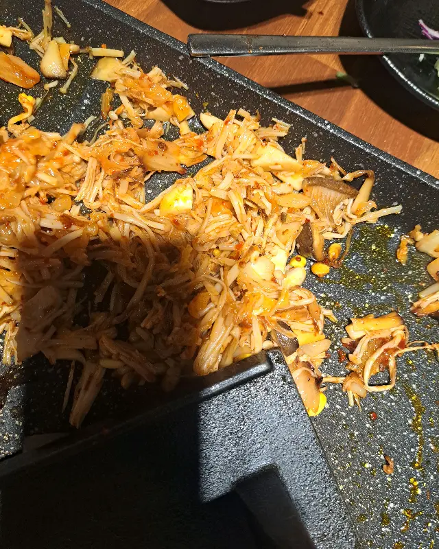 불판 위에서 맛있게 익어가는 김치와 버섯