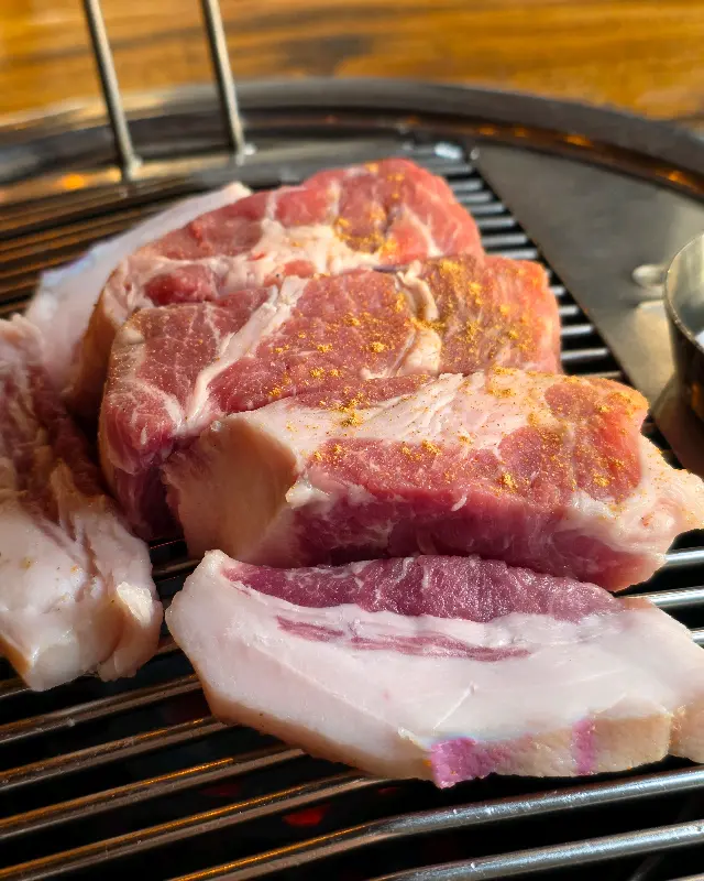 숯불 위에서 맛있게 익어가는 흑돼지 목살과 오겹살