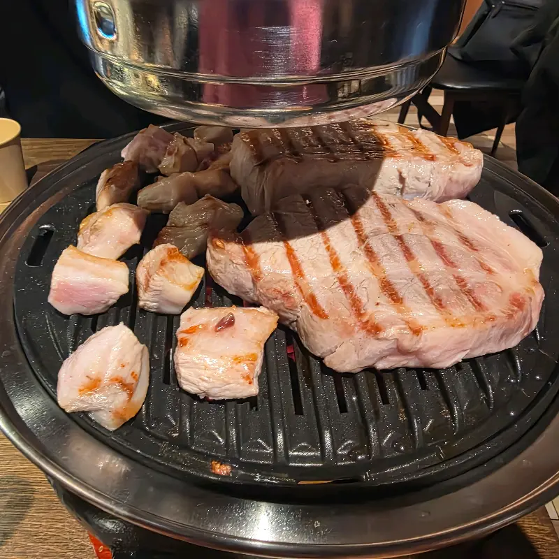 숯불 위에서 익어가는 삼겹살과 목살