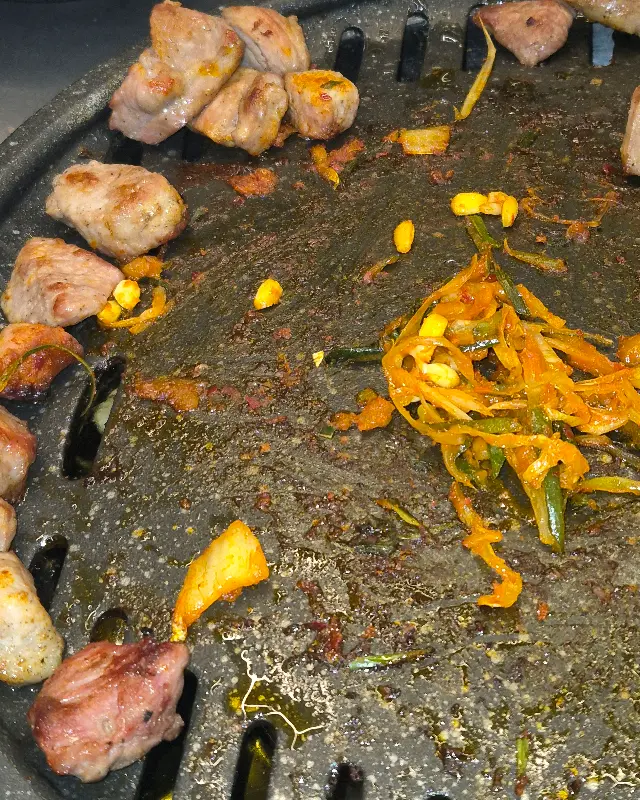 불판 위에서 맛있게 익어가는 김치와 파절이