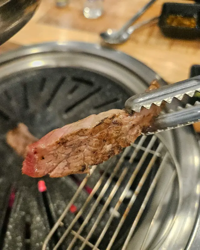 잘 익은 소고기를 젓가락으로 집어 올리는 모습