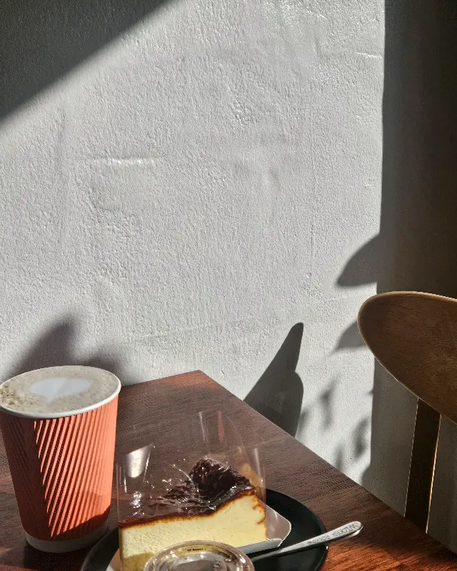 햇살이 드리운 테이블 위의 케이크와 커피