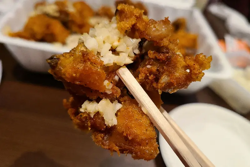 젓가락으로 집어올린 마늘 치킨