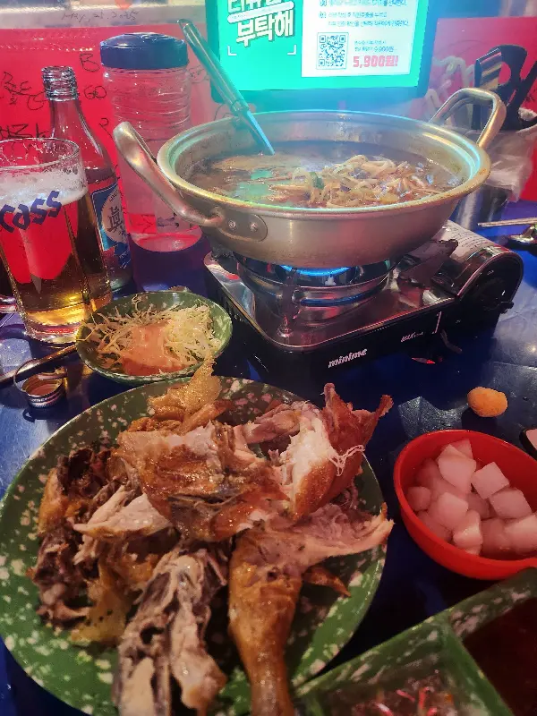 테이블 위에서 가스 버너에 올려진 냄비 안에는 김치 우동이 보글보글 끓고 있었다. 붉은 국물 위에는 김치와 유부, 쑥갓이 푸짐하게 올려져 있었다.