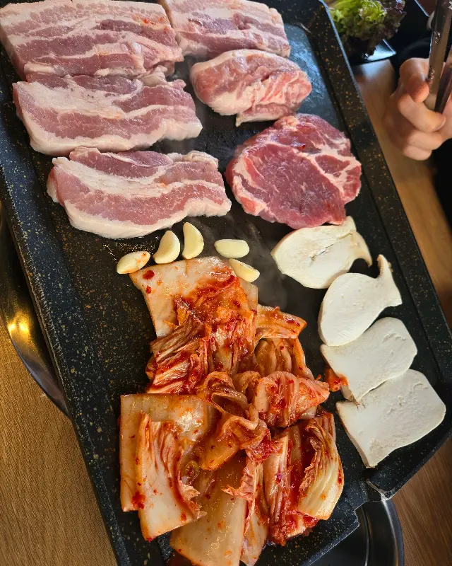 불판 위에 올려진 삼겹살과 김치