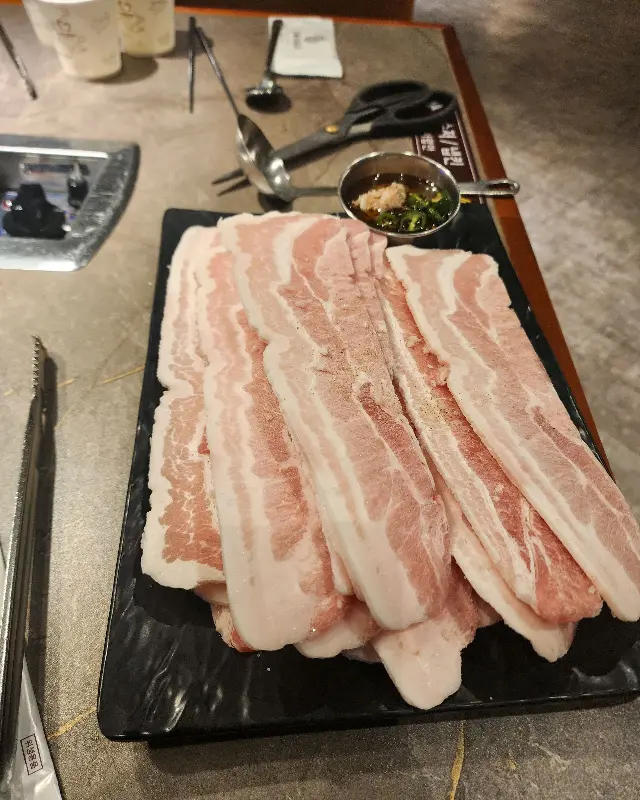 테이블 위에 놓인 삼겹살 한 접시