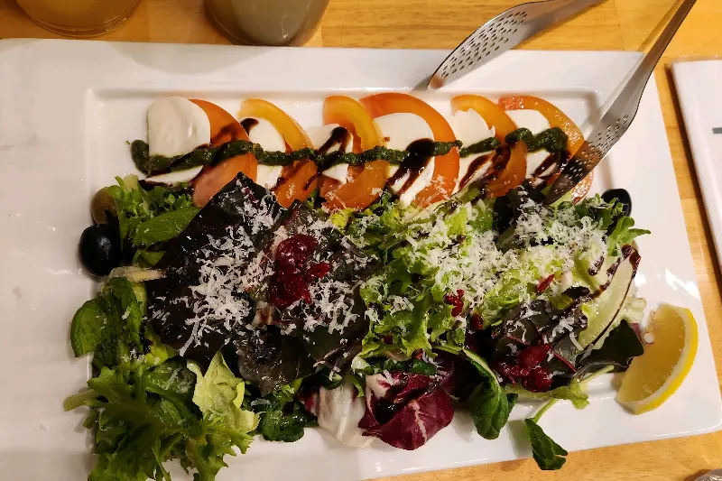 신선한 토마토와 모짜렐라 치즈가 층층이 쌓인 토마토 카프레제 샐러드