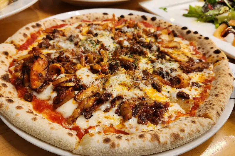 화덕에서 갓 구워져 나온 따뜻한 한우 1++ 라구 피자