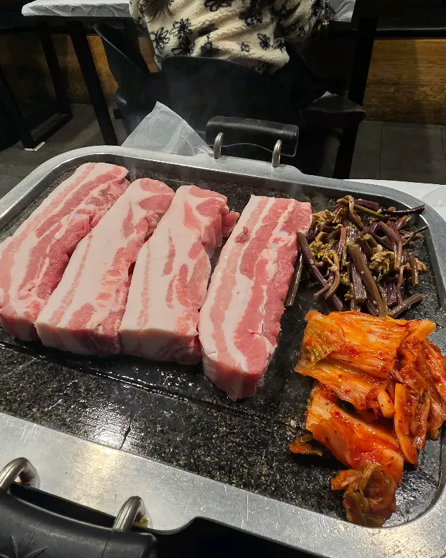 불판 위의 삼겹살과 김치, 고사리