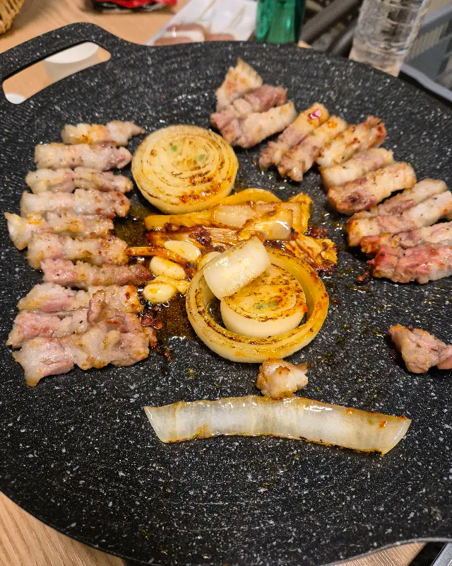 숯불 위에서 익어가는 삼겹살과 양파