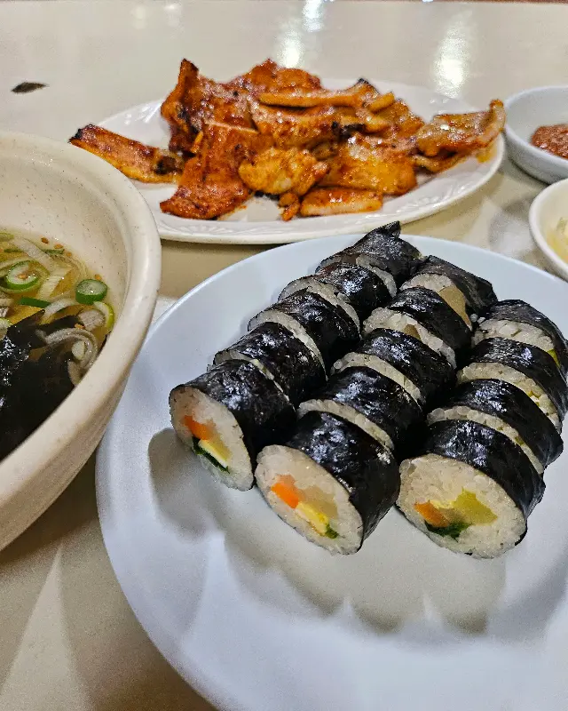 돼지불고기, 김밥, 가락국수가 차려진 테이블