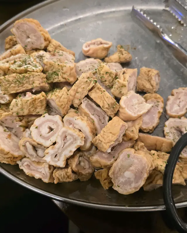 불판 위에 가지런히 놓인 막창, 떡, 버섯