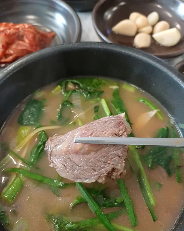 젓가락으로 들어올린 곰탕 속 부드러운 고기
