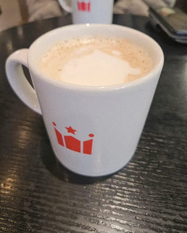 할리스의 상징적인 붉은색 로고가 새겨진 라떼