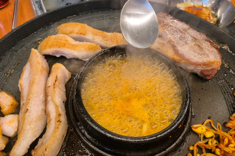 솥뚜껑 위에서 지글거리는 삼겹살과 된장찌개