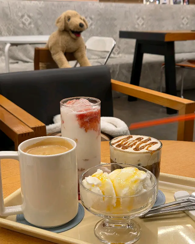 음료와 디저트가 놓인 테이블과 강아지 인형