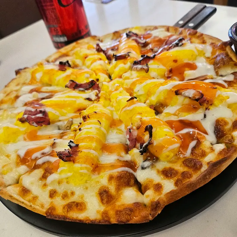 동그란 접시에 담긴, 먹음직스러운 노란색의 골든 에그 피자