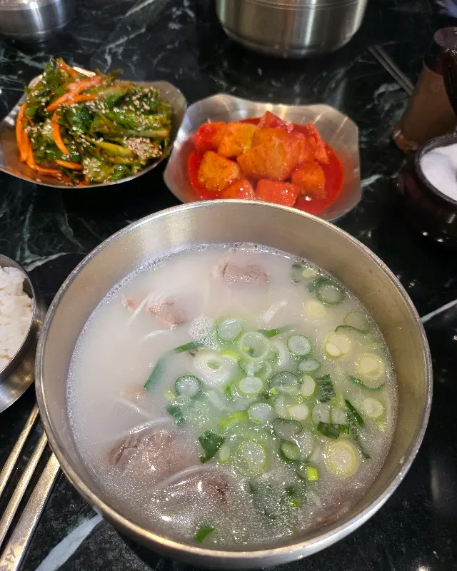 설렁탕에 밥을 말아 깍두기를 올려 먹는 모습