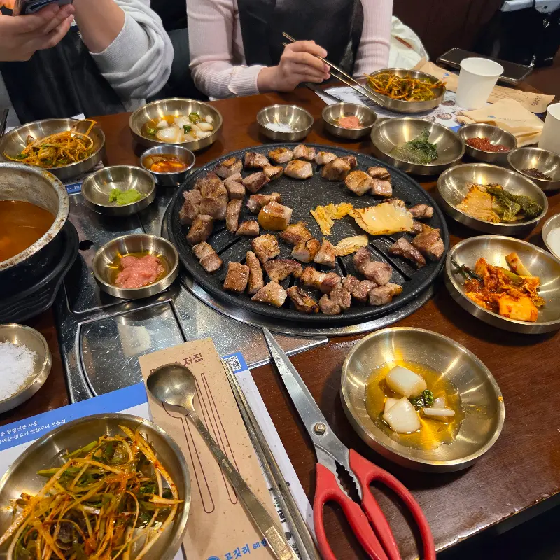 다양한 밑반찬과 구워진 고기가 올려진 테이블 전경