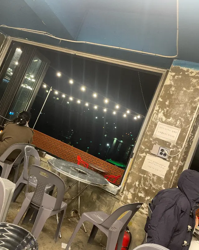 밤에 찍은 식당 창가 좌석 사진. 창 밖으로 조명이 켜진 삼천포대교가 보인다.