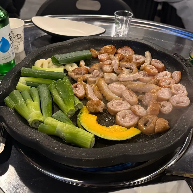 불판 위에서 익어가는 막창과 야채들