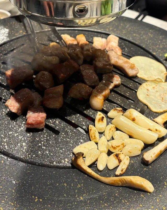 숯불 위에서 익어가는 다양한 종류의 고기