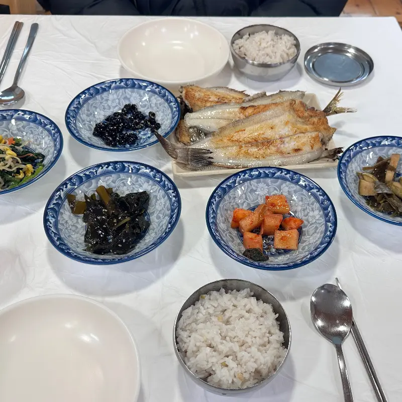 가자미구이와 다채로운 밑반찬이 놓인 식탁