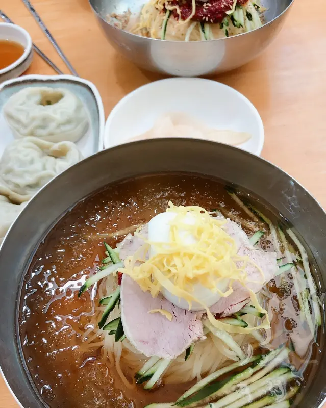 테이블 위에 놓인 밀면과 만두