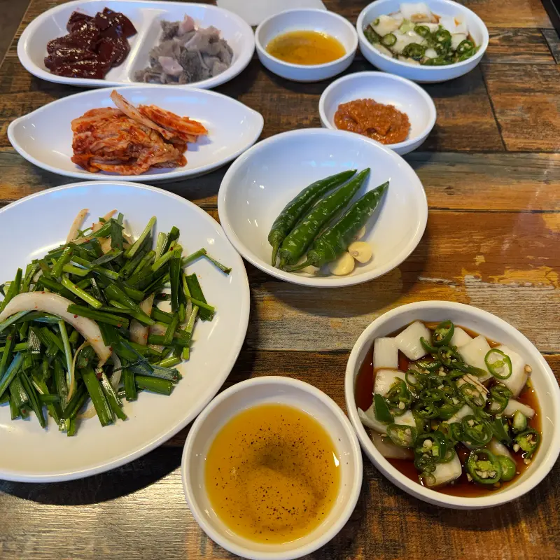 잘 구워진 곱창 한 점을 젓가락으로 집어 올리는 모습