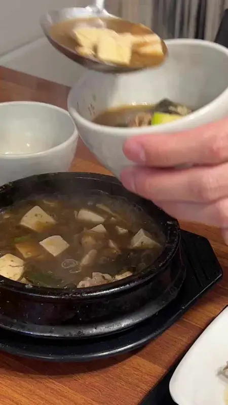 뚝배기에 담긴 차돌된장찌개를 개인 그릇에 담는 모습