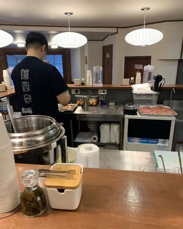 오픈 키친에서 라멘을 만드는 요리사