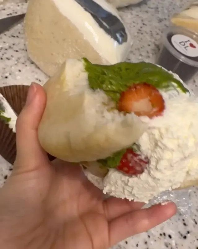 손에 들린 말차 딸기 샌드 베이글