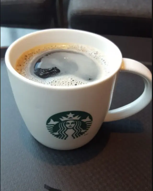 스타벅스 로고가 새겨진 머그컵에 담긴 따뜻한 아메리카노