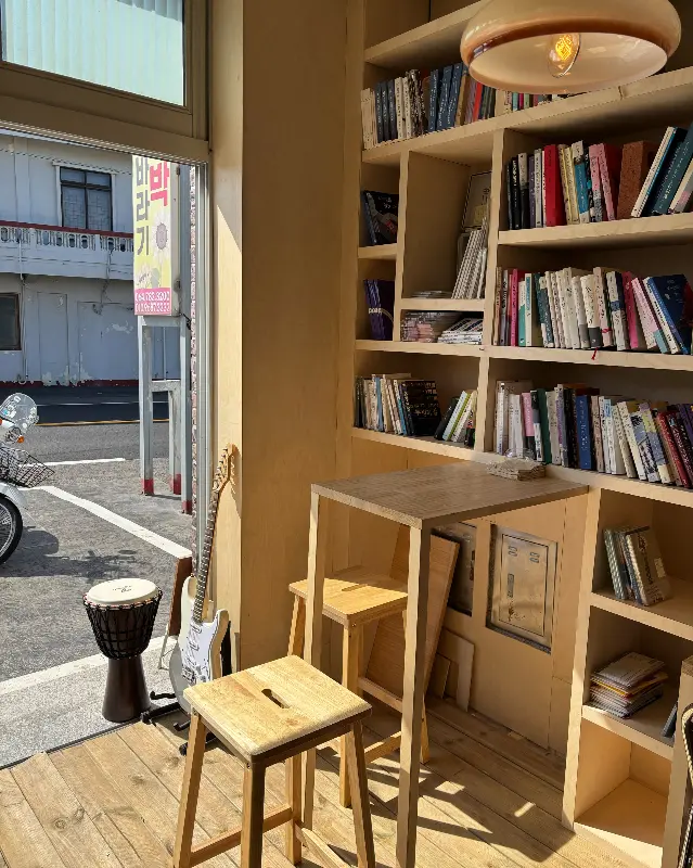 책장과 테이블, 의자가 있는 카페 내부