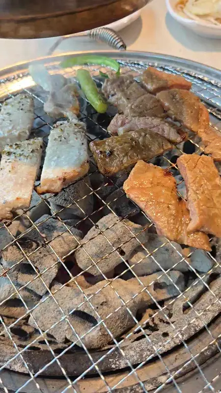 숯불 위에서 돼지갈비와 껍데기를 함께 굽는 모습