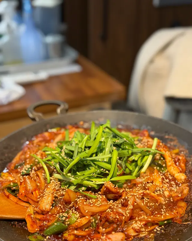 매콤한 양념에 버무려진 곰장어 위에 신선한 채소가 듬뿍 올려져 있다.