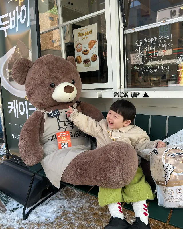카페 입구에 놓인 곰인형과 아이